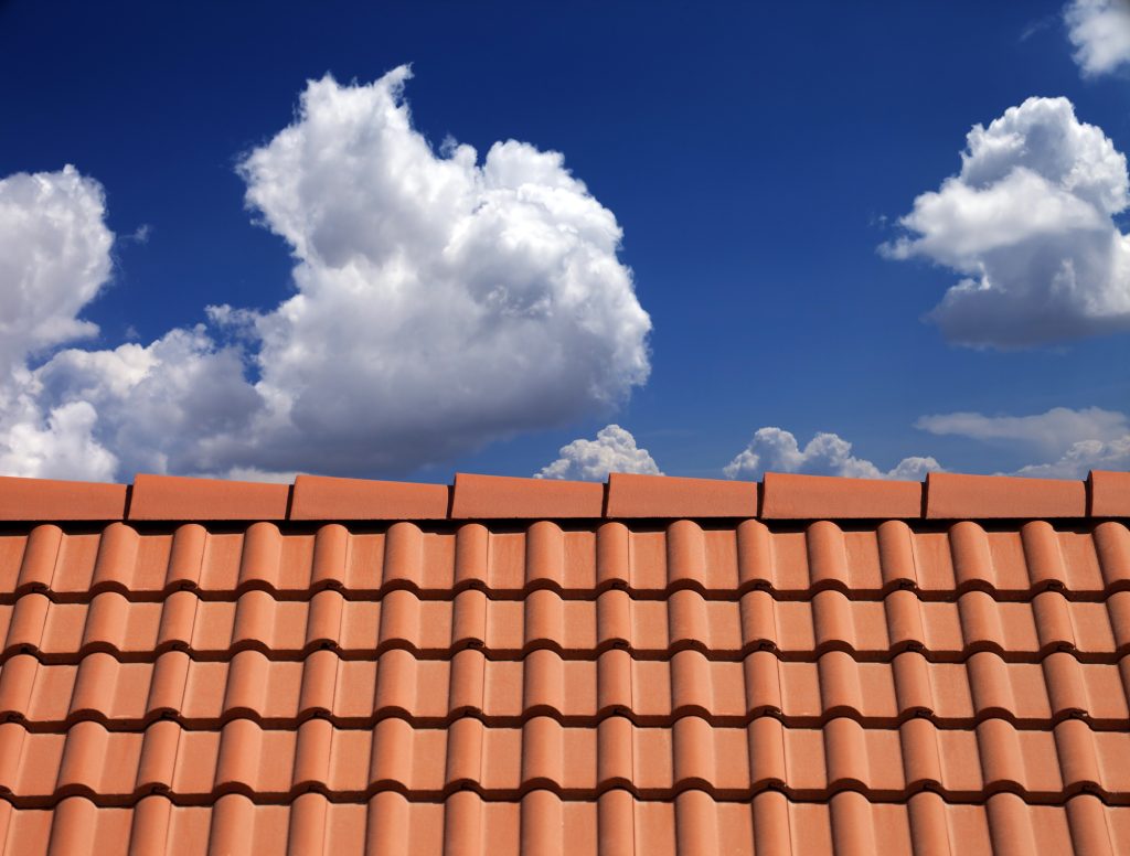 Roof Tiles Against Blue Sky With Clouds