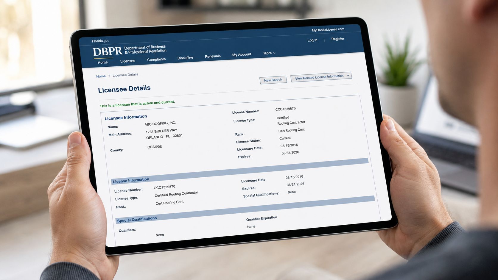 A person holding a tablet displaying official Florida business license details for a roofing company online.